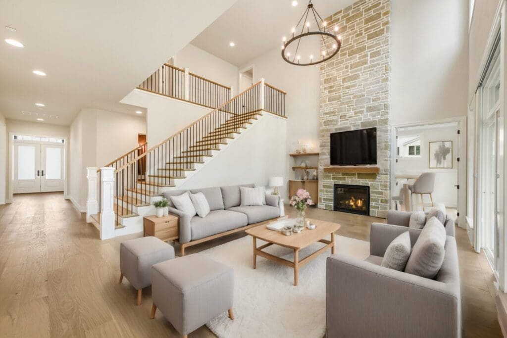 Modern living room with elegant design features, including a stone fireplace, plush seating, and large windows, located in the Pacific Northwest.