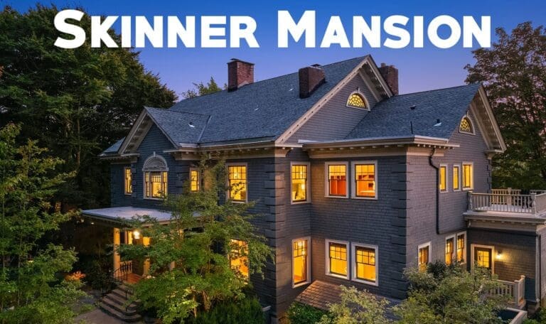 Elegant exterior of Skinner Mansion, showcasing classic architectural details and warm lighting against a twilight sky in the Pacific Northwest.