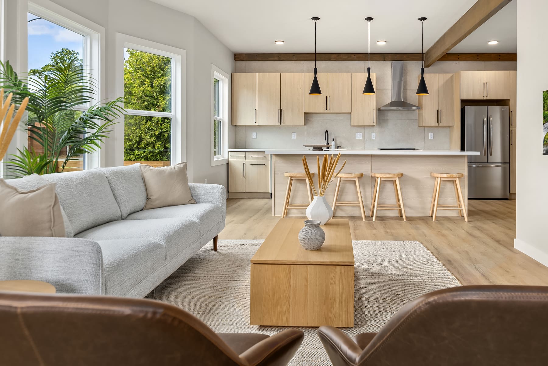 Modern open-concept living space featuring a stylish kitchen and cozy seating area, with natural light streaming in from large windows. Located in the Pacific Northwest.