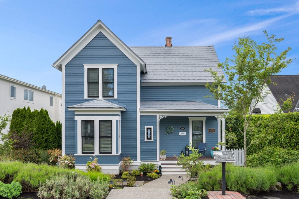 Kirkland Buchanan House Charming blue Victorian-style home exterior with landscaped garden in Seattle, showcasing a welcoming porch and modern design elements.