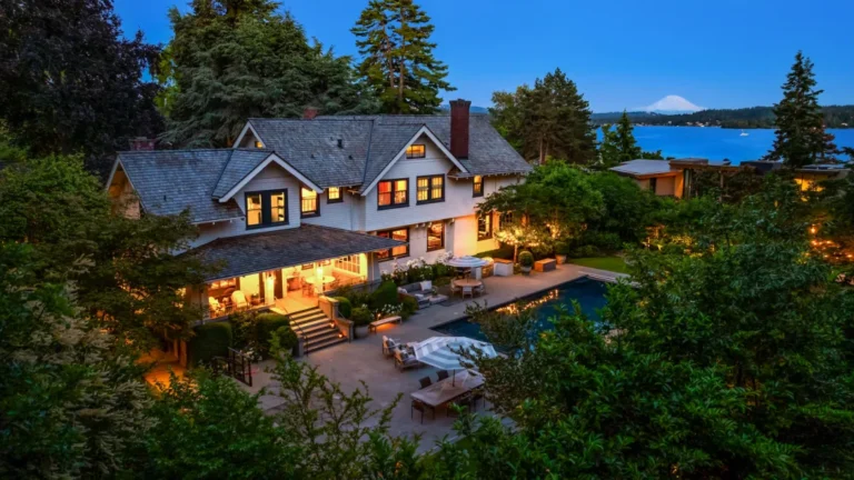 Stunning exterior view of a modern home in the Pacific Northwest, featuring lush greenery, a swimming pool, and warm evening lighting, creating an inviting atmosphere.